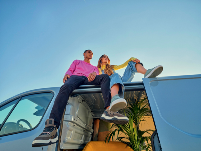 Couple on roof of Renault scenic on a sunny day with door open and plant inside