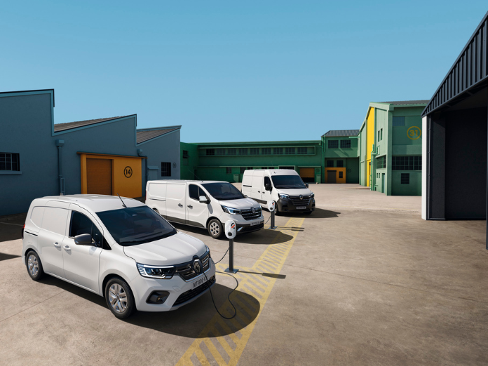 White Renaul kangoo trafic master vans charging with mobilize powerbox in front of blue and green office buildings