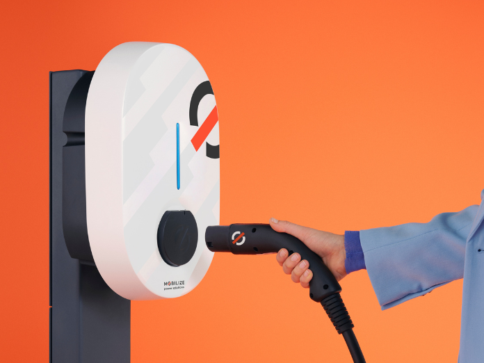 mobilize powerbox EV charger with hand holding charging cable with orange background