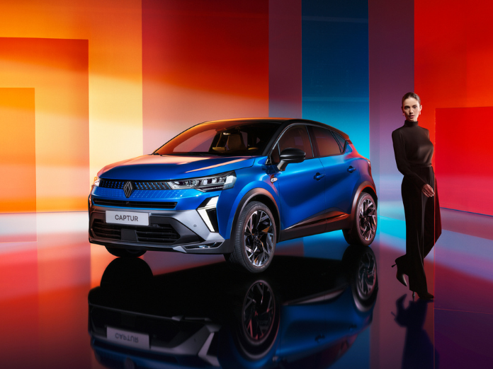 Blue Renault Captur with lady in black trousers and polo neck jumper with colourful blocked background